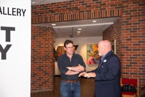 Professor Steve Neves talking to someone at an art show