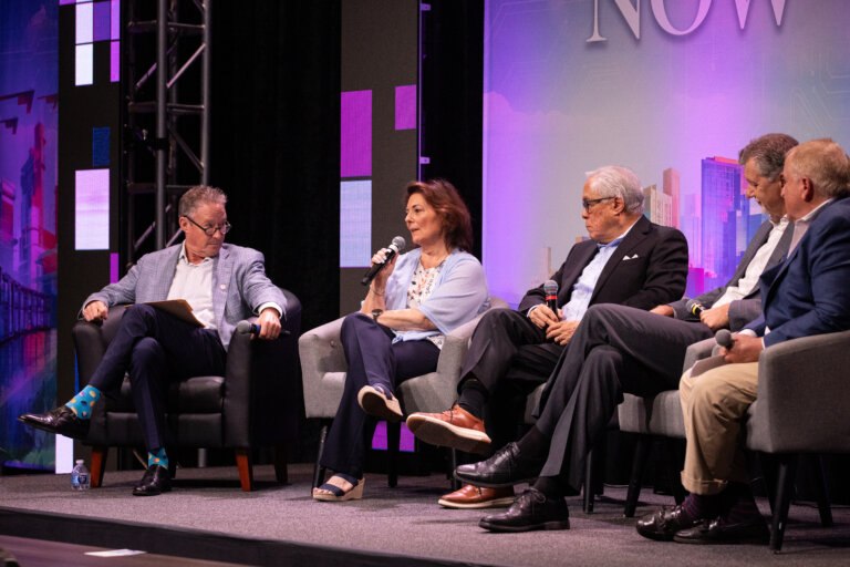 Speakers speak on stage at The Future is Now summit
