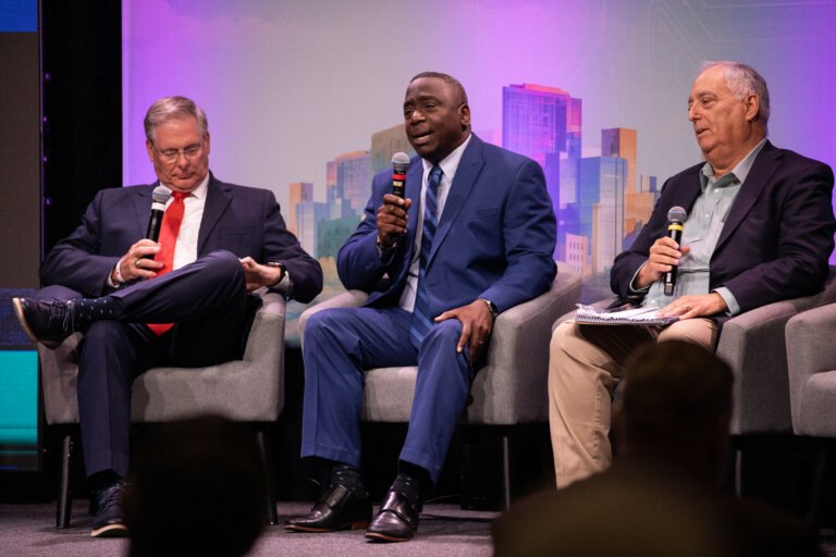 Speakers speak on stage at The Future is Now summit