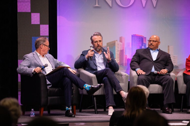 Speakers speak on stage at The Future is Now summit