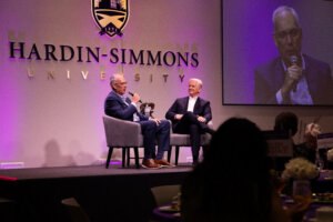 Derrick Duke sitting and talking with Eric Bruntmyer on stage